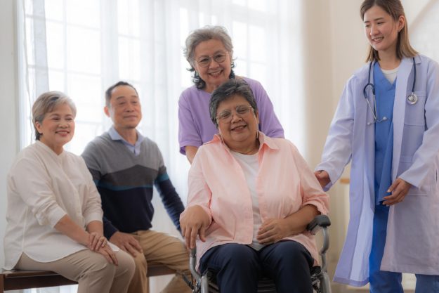 Asian young nurse support couple senior older woman in a wheelch